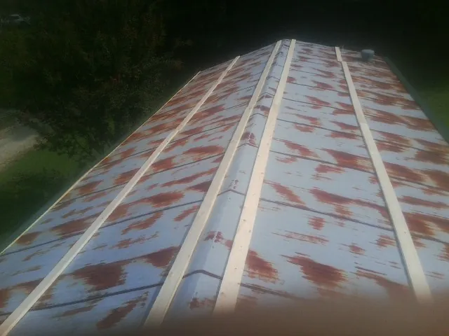 Rusted metal roof panels with new wood purlins before replacement — Storm Damage Roof Repair in McMinnville by Roofing Brothers