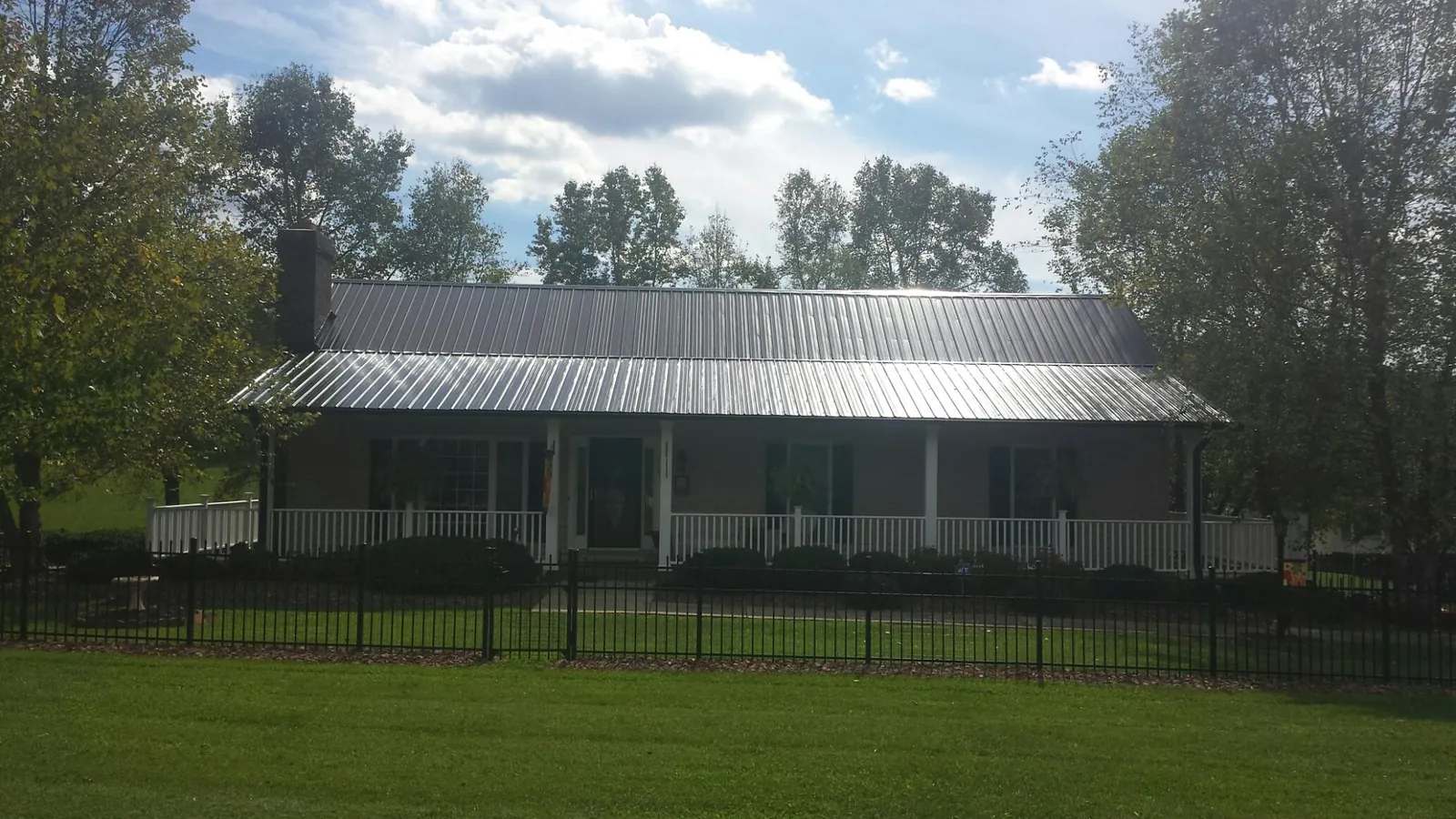 Gray metal roof on a brick ranch with a full width front porch — Gutter Guard Installation work by our crew in McMinnville